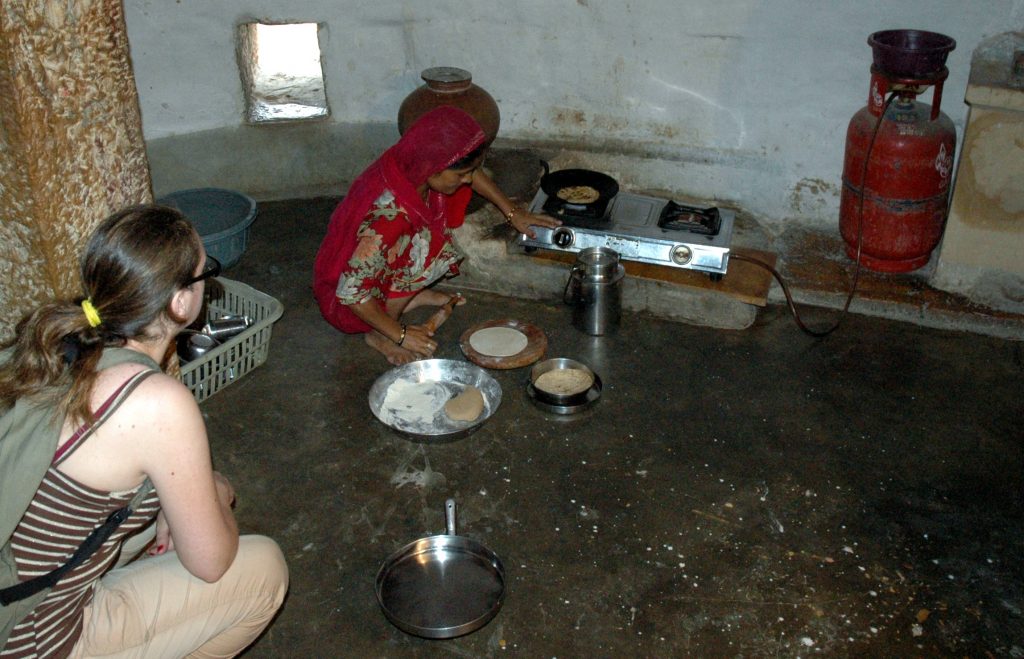 Jaisalmer, una donna cucina il pane indiano roti con il tawa